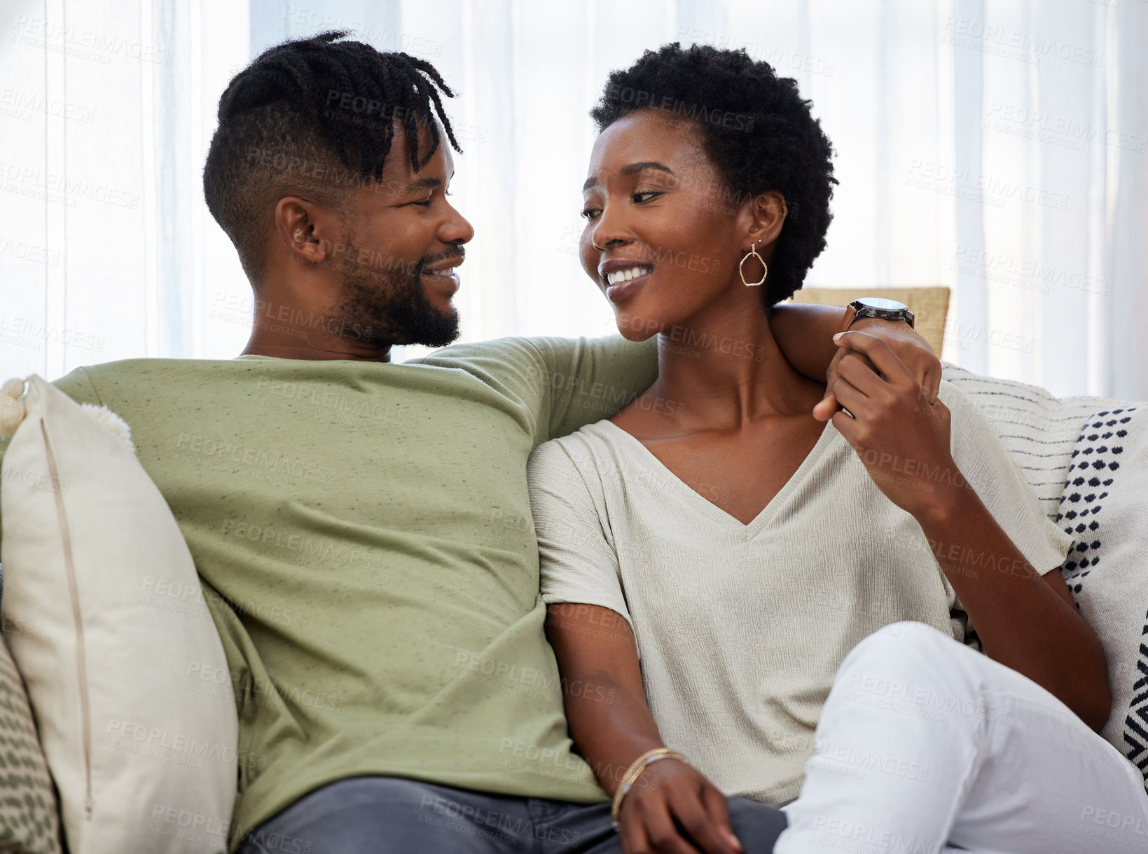 Buy stock photo Shot of a young couple bonding while sitting on the couch at home