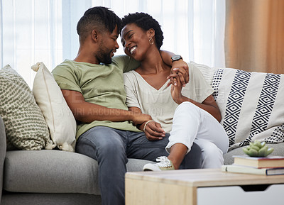 Buy stock photo Shot of a young couple sitting on a couch at home