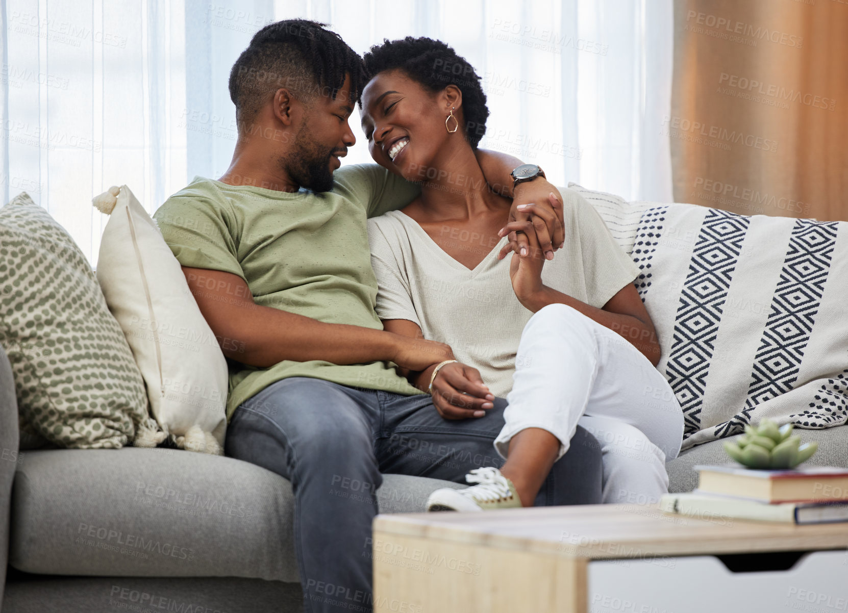 Buy stock photo Shot of a young couple sitting on a couch at home