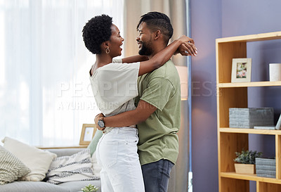 Buy stock photo Shot of a young couple dancing in the living room at home