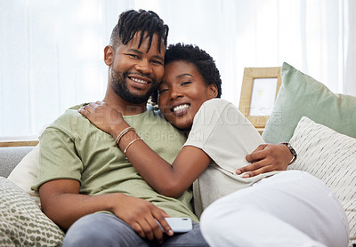 Buy stock photo Shot of a young couple sitting on the couch at home