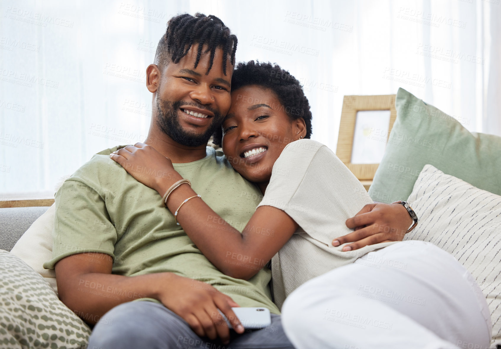 Buy stock photo Portrait, couple and love with smile in home for commitment, marriage and happy together on sofa. Man, African woman and hug in apartment for morning, partner and romance in living room for relax 