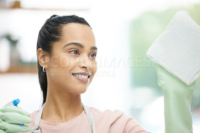 Buy stock photo Shot of a young woman cleaning a glass window at home