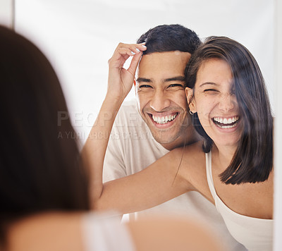 Buy stock photo Shot of a happy young couple standing together in their bathroom in the morning