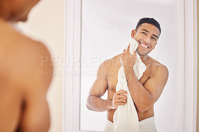 Buy stock photo Shot of a handsome young man standing alone in his bathroom at home and using a towel after his shower