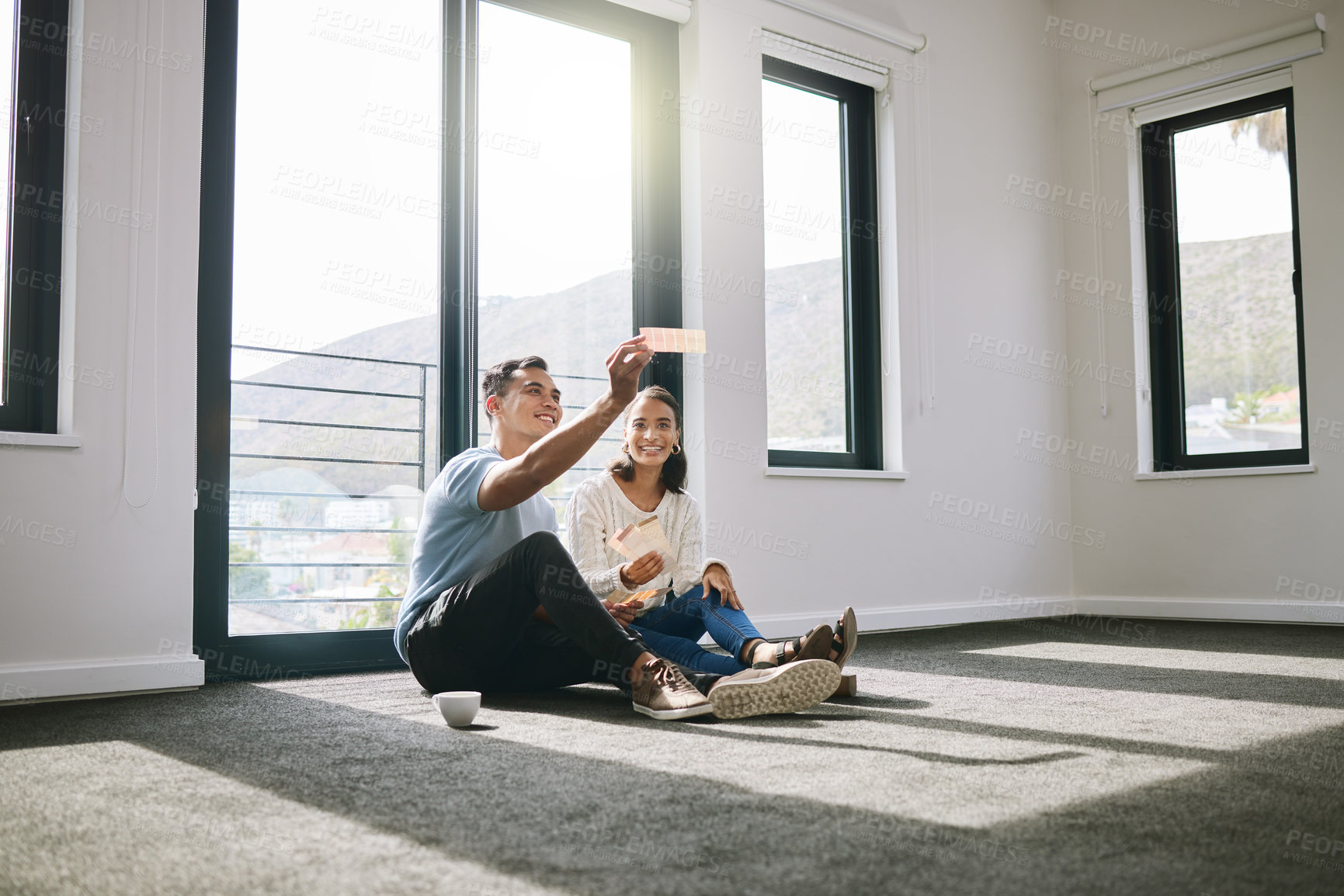 Buy stock photo Full length shot of a young couple sitting together and planning the interior design of their new home