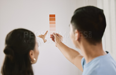 Buy stock photo Shot of an unrecognizable couple standing together and planning the interior design of their new home