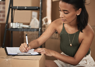 Buy stock photo Shot of a young woman signing a contract at home