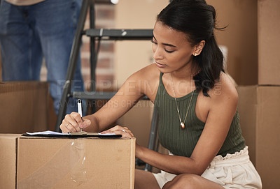 Buy stock photo Shot of a young woman signing a contract at home