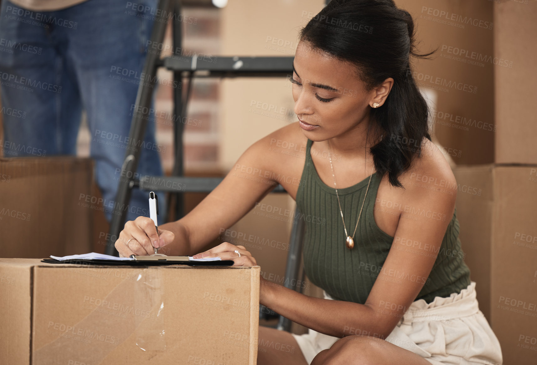 Buy stock photo Shot of a young woman signing a contract at home