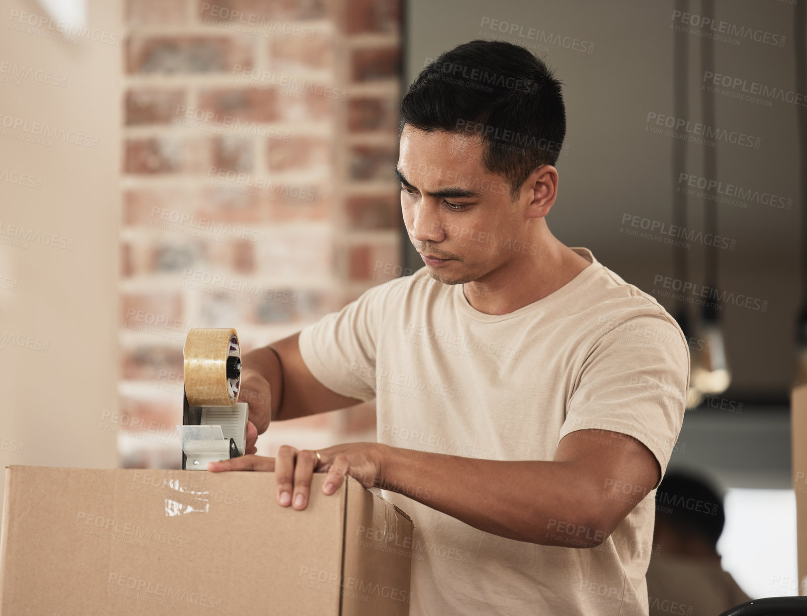Buy stock photo Shot of a young man packing up to move in a room at home
