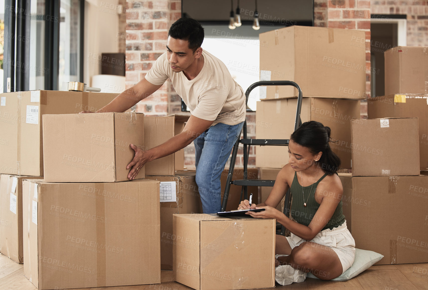 Buy stock photo Shot of a young couple packing up to move in a room at home