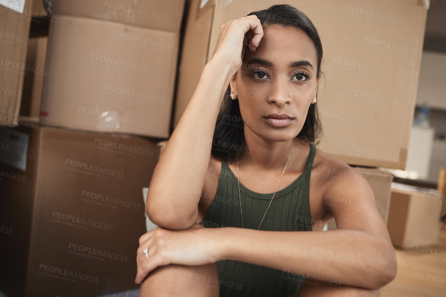 Buy stock photo Shot of a young woman being upset while sitting on the floor at home