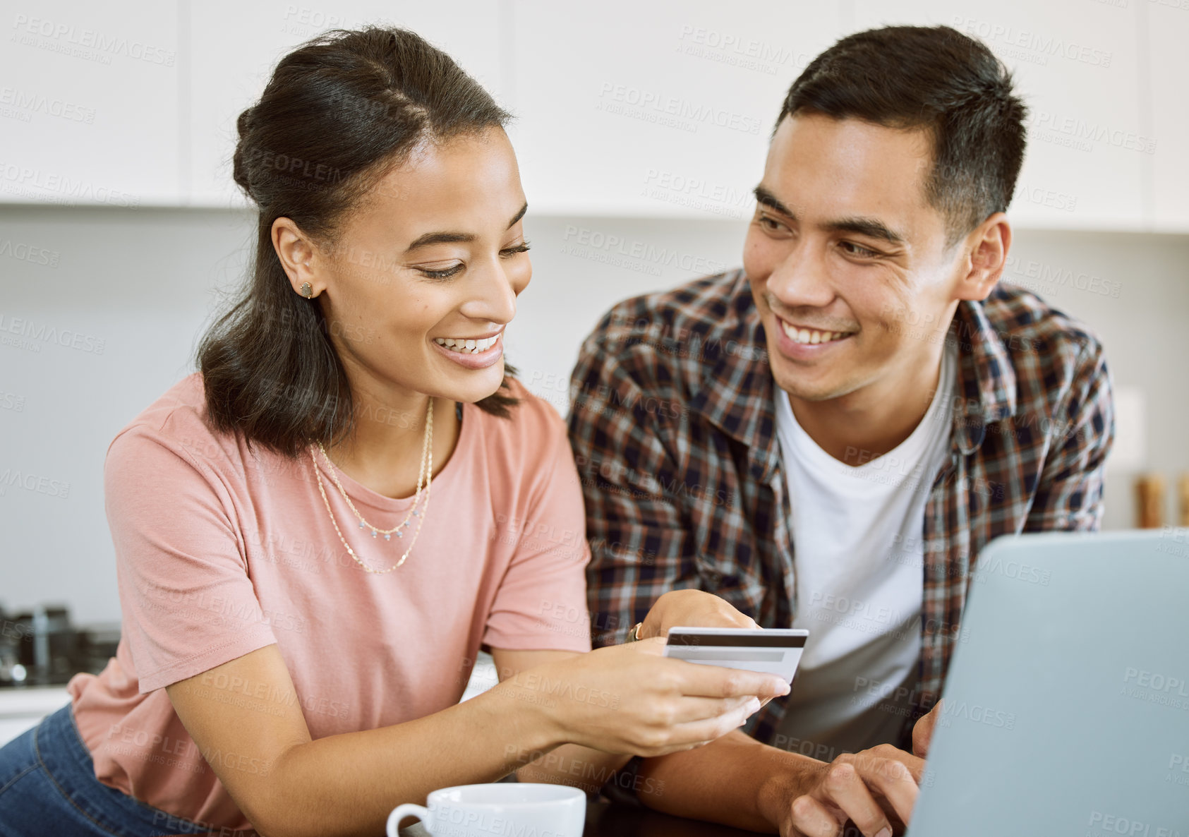 Buy stock photo Shot of a young couple buying items online at home