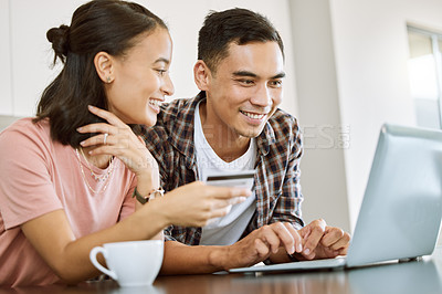 Buy stock photo Shot of a young couple buying items online at home