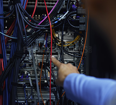 Buy stock photo Cropped shot of an unrecognizable male IT support agent working in a dark network server room