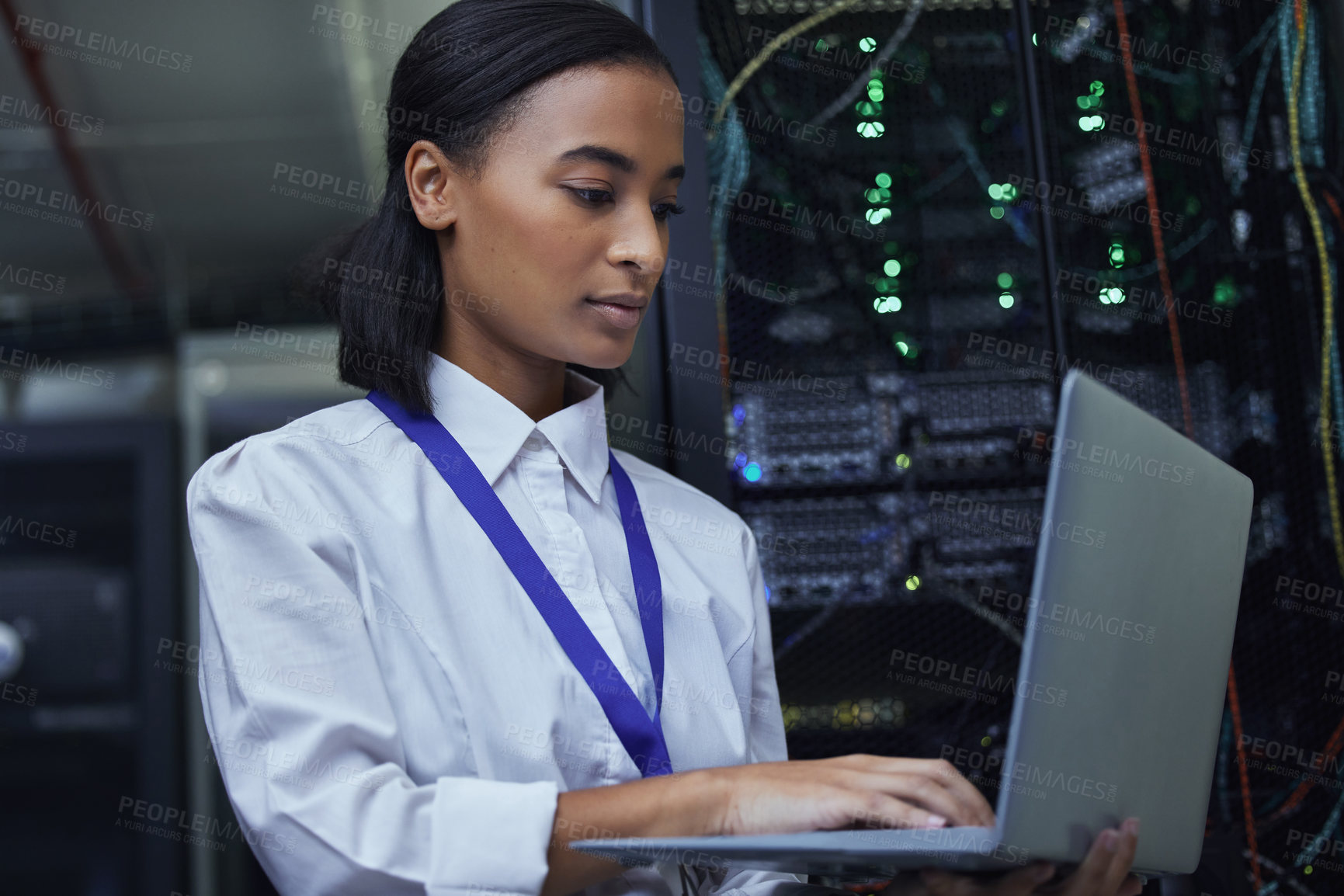 Buy stock photo Cropped shot of an attractive female IT support agent working in a dark network server room