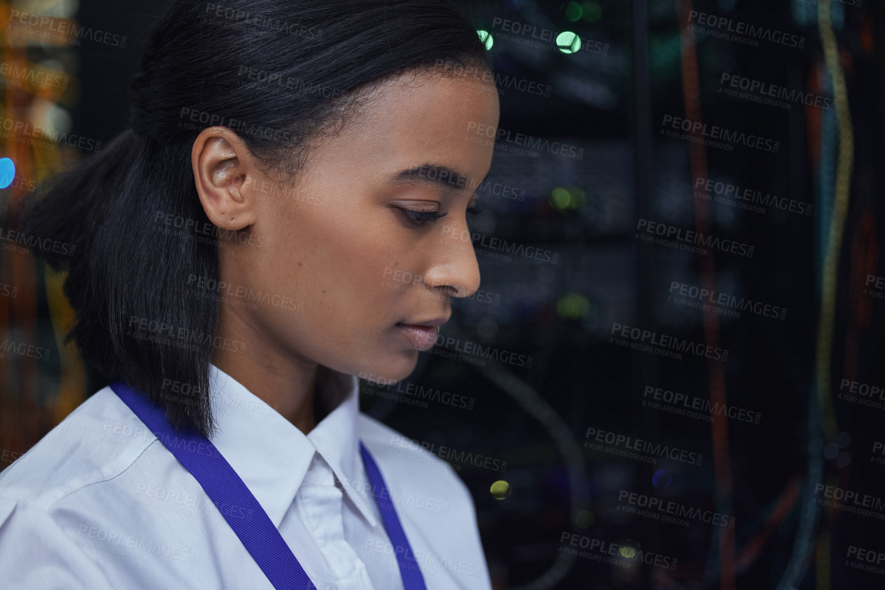 Buy stock photo Cropped shot of an attractive female IT support agent working in a dark network server room