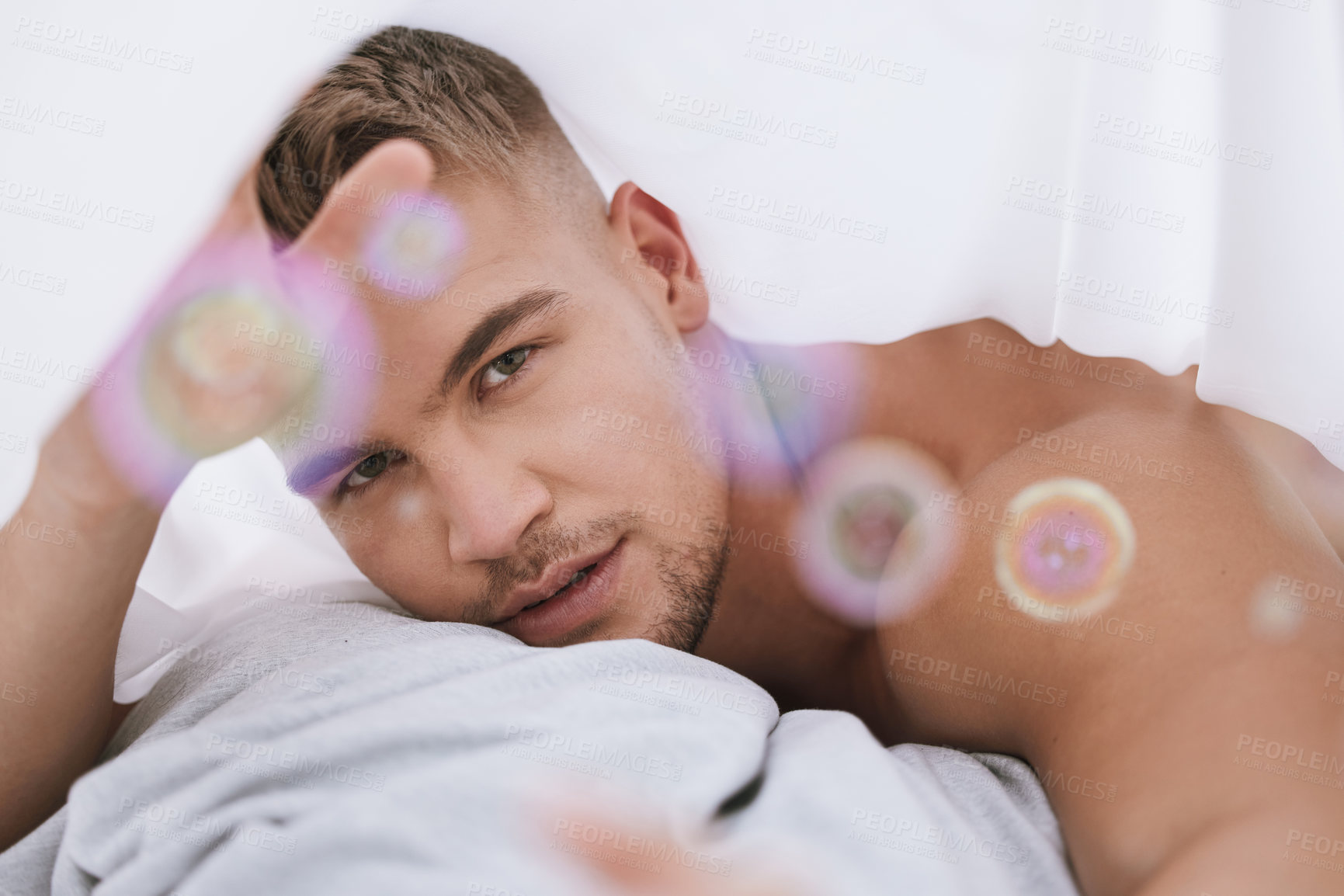 Buy stock photo Morning, portrait or topless man with pillow in bedroom for resting in home, house or apartment to relax. Wake up, lens flare or guy sleeping on break with peace, bedding or wellness on weekend chill