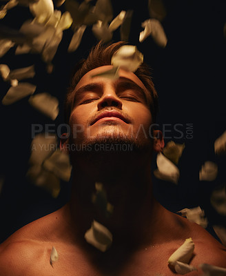 Buy stock photo Shot of a handsome young man with no shirt on standing in the shadows