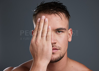 Buy stock photo Studio portrait of a handsome and hunky young man posing in studio against a gray background