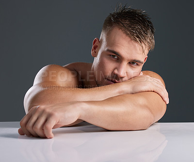 Buy stock photo Studio portrait of a handsome and hunky young man posing in studio against a gray background