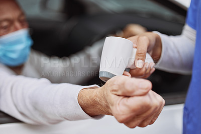 Buy stock photo Shot of an unrecognizable healthcare worker taking a patient's temperature at a drive through vaccination site