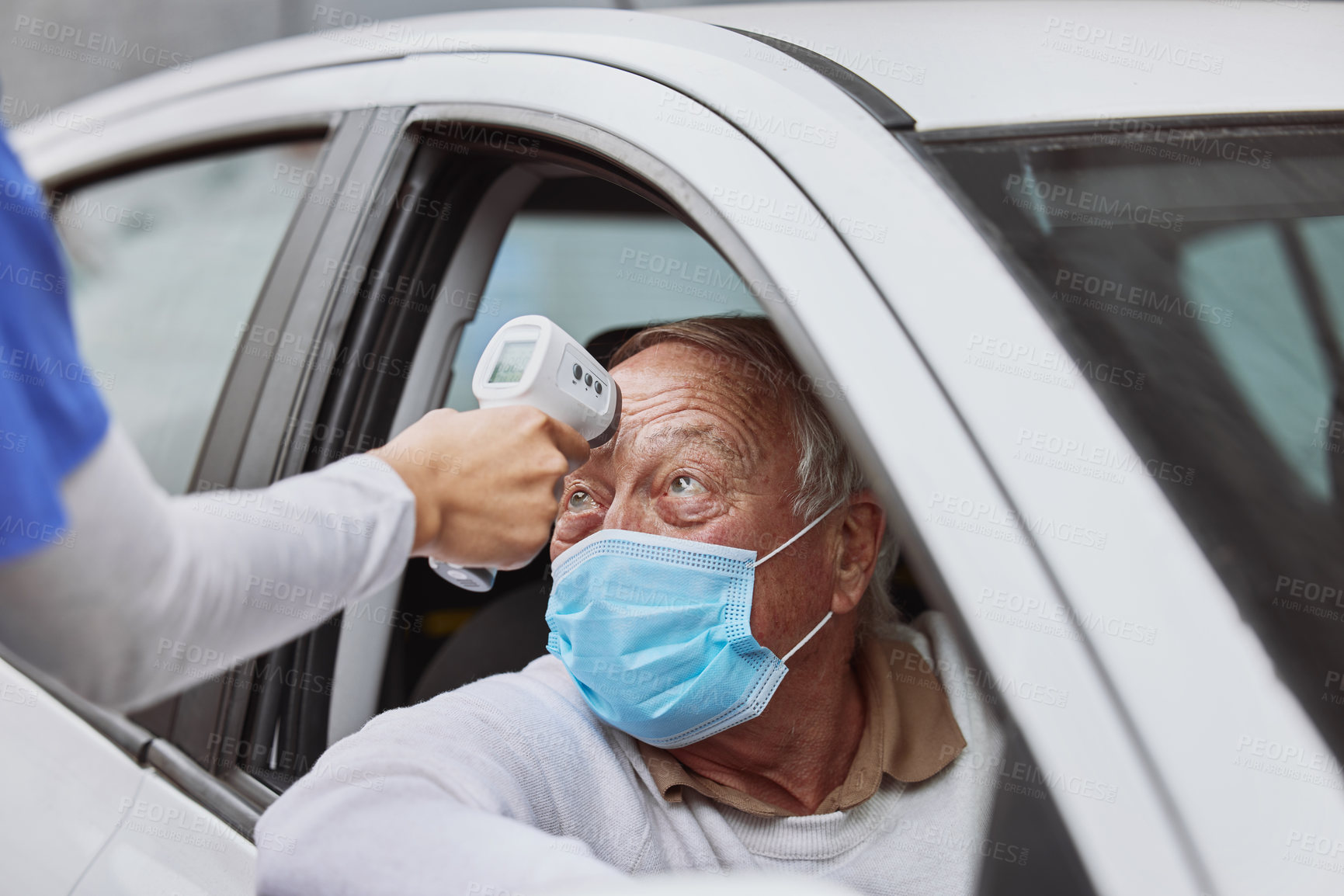 Buy stock photo Shot of a senior man getting his temperature taken at a drive through vaccination site