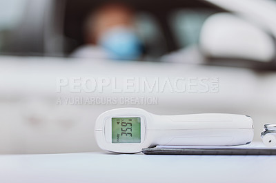 Buy stock photo Shot of a thermometer on a table at a drive through vaccination site