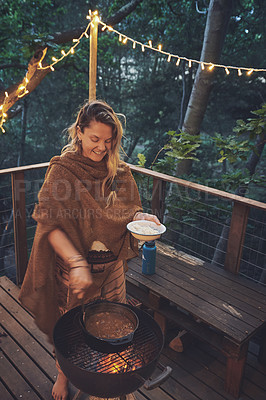 Buy stock photo Shot of a woman dishing food from the grill on a cabin porch