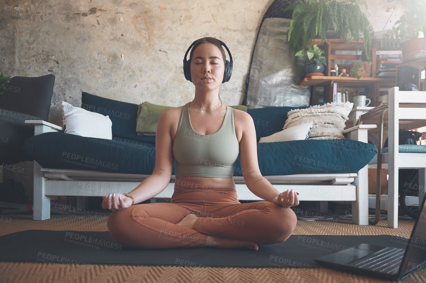 Buy stock photo Shot of a young woman meditating while practising yoga at home