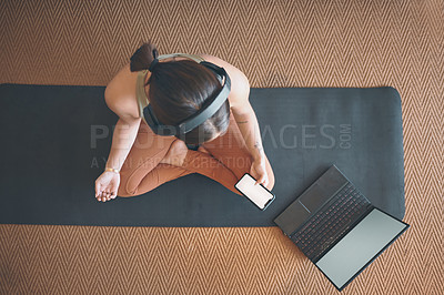 Buy stock photo High angle shot of a young woman using a cellphone and laptop while exercising at home