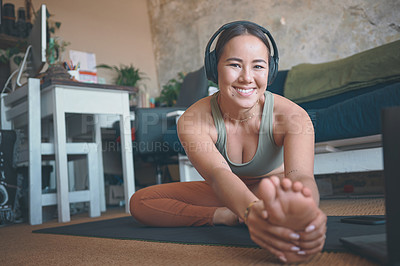 Buy stock photo Portrait of a young woman stretching her legs while exercising at home