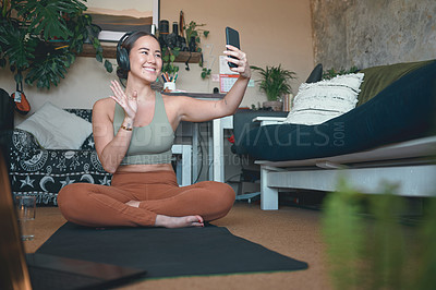 Buy stock photo Shot of a young woman using a cellphone while exercising at home