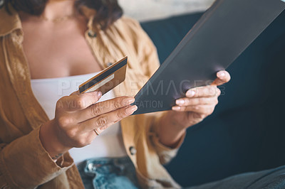 Buy stock photo Shot of an unrecognisable woman using a digital tablet and credit card on the sofa at home