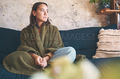 Buy stock photo Shot of a young woman resting under a blanket on the sofa at home