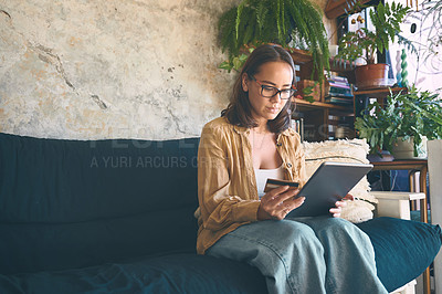 Buy stock photo Shot of a young woman using a digital tablet and credit card on the sofa at home