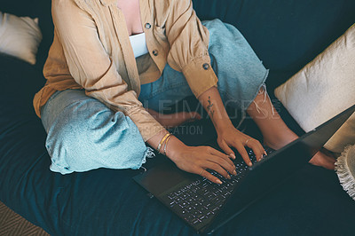 Buy stock photo Shot of an unrecognisable woman using a laptop on the sofa at home