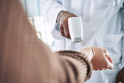 Buy stock photo Cropped shot of an unrecognizable doctor standing with a patient in the clinic while taking her temperature