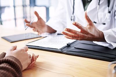 Buy stock photo Cropped shot of an unrecognizable doctor sitting with his patient and explaining her diagnosis during a consultation in the clinic