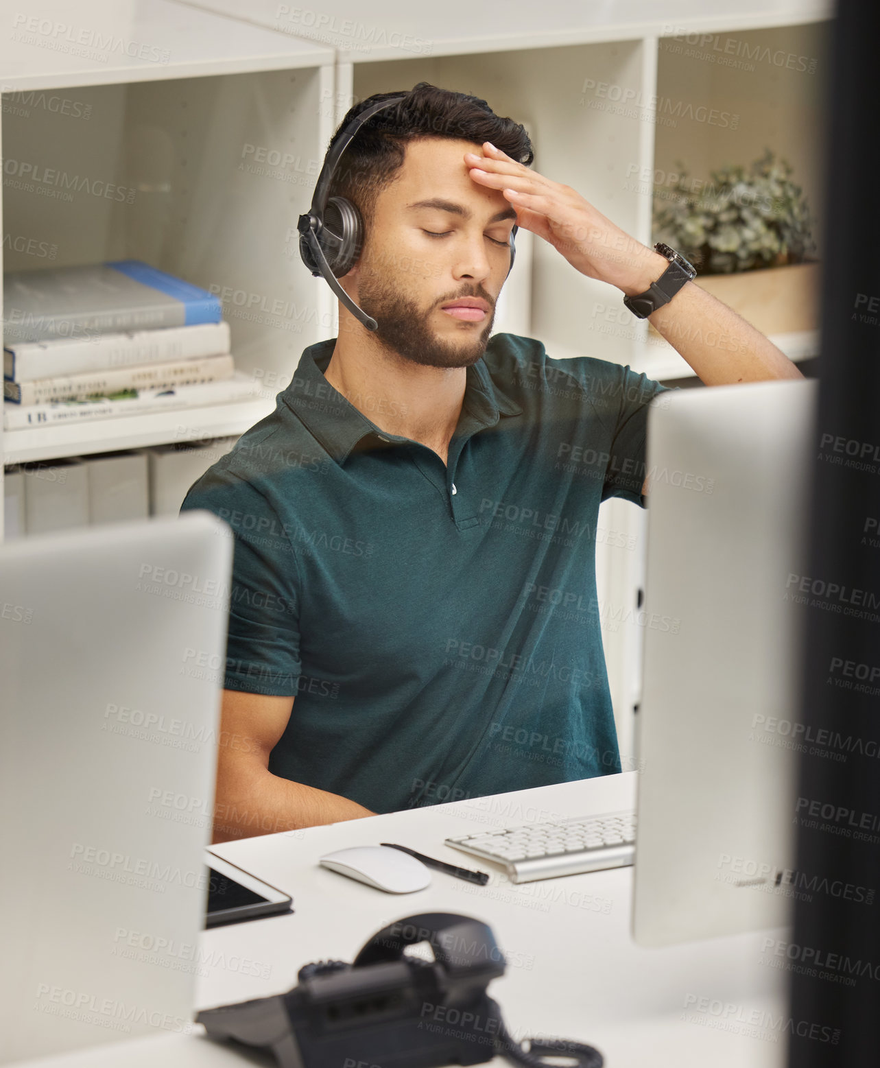 Buy stock photo Shot of a businessman looking stressed while working in a call center