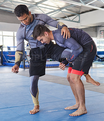 Buy stock photo Full length shot of a jiu jitsu sensei sparring with one of his students during a class