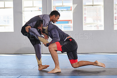Buy stock photo Full length shot of a jiu jitsu sensei sparring with one of his students during a class