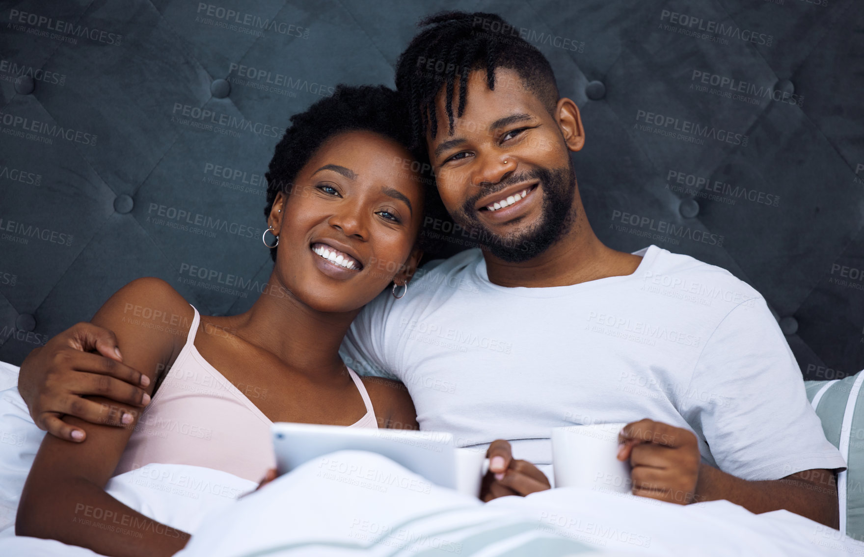 Buy stock photo Couple, bedroom and relax in portrait with tablet and coffee for morning bonding, weekend and online streaming. Face of African man and woman with hug and love on digital tech for movies at home