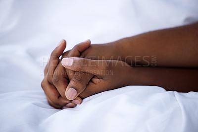 Buy stock photo Shot of an unrecognisable couple holding hands in bed at home