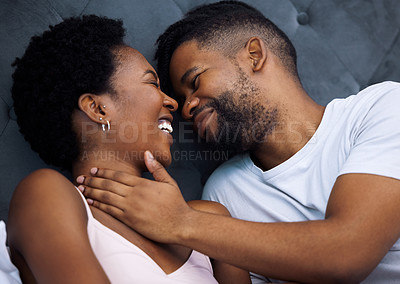 Buy stock photo Shot of a young couple being intimate in bed at home