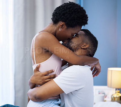 Buy stock photo Shot of a young couple being intimate in bed at home