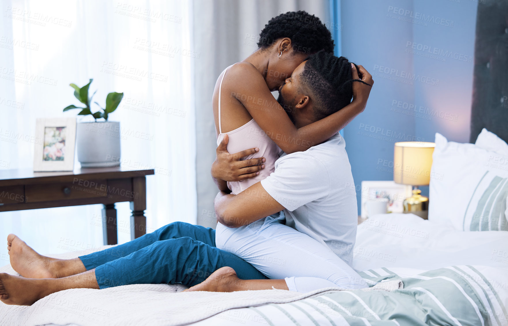 Buy stock photo Happy, black couple and kiss in embrace, bedroom for romance, love and connection as partner in relationship. African woman and man for support with intimacy, emotion in marriage for bonding or trust