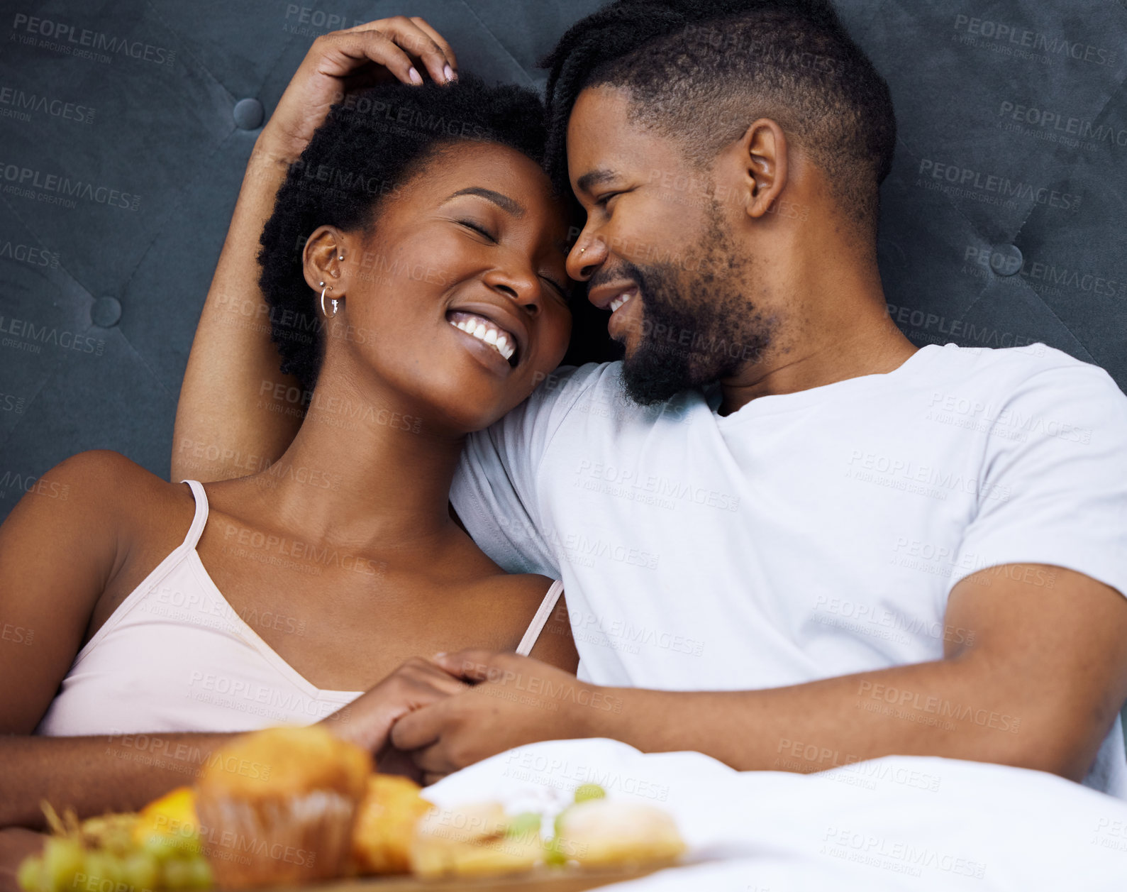 Buy stock photo Black couple and bed on honeymoon with love for marriage with husband, wife and affection together. Smile, embrace and cheerful with care for partner, happy and romantic getaway weekend in Paris.