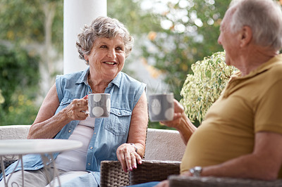 Buy stock photo Shot of a senior couple having coffee and sharing a conversation in a garden